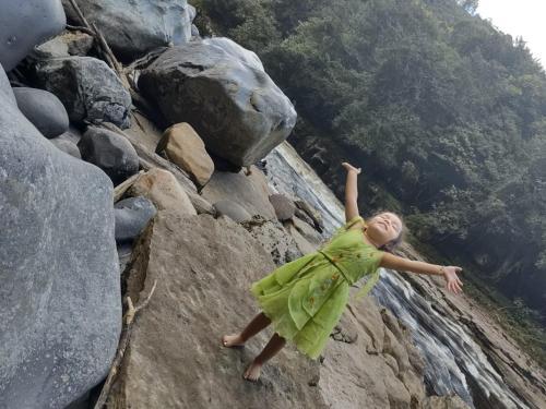a young girl in a green dress standing on a rock at Cabañas Guacari San Agustín huila in San Agustín