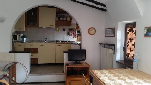 a kitchen with an archway and a tv in a room at via vione 70 bis in San Bartolomeo al Mare