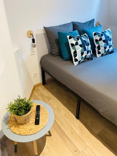 a couch with pillows and a table in a room at BE MY APPARTS, Studio de charme "LE COSY", DOUAI, Coeur de ville in Douai