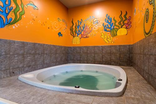 a bathroom with a bath tub in a room at Best Western Plus Grand-Sault Hotel & Suites in Grand Falls