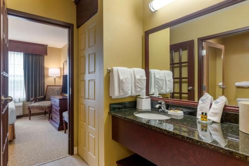 a bathroom with a sink and a large mirror at Best Western Plus Grand-Sault Hotel & Suites in Grand Falls
