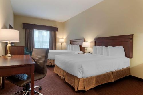 a hotel room with two beds and a desk at Best Western Plus Fredericton Hotel & Suites in Fredericton