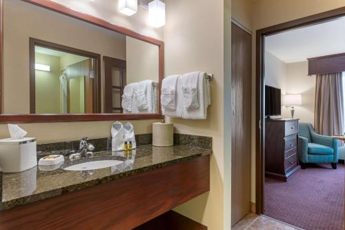 a bathroom with a sink and a mirror at Best Western Plus Fredericton Hotel & Suites in Fredericton