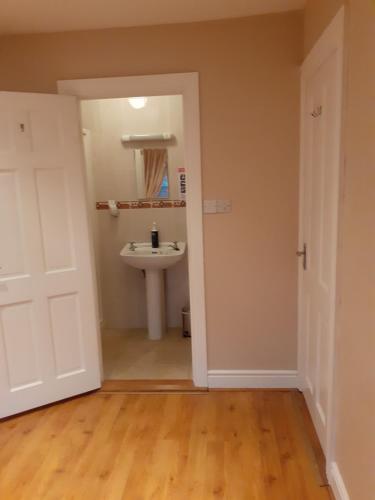 a bathroom with a sink and a white door at Mels accomodation in Letterkenny