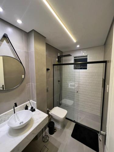 een badkamer met een wastafel, een toilet en een douche bij Lindo Apartamento em Frente a Praia - Santos in Santos