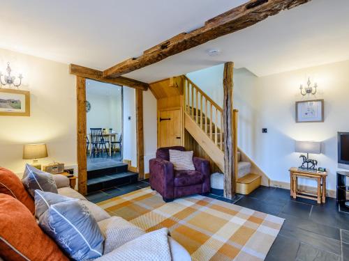 a living room with a couch and a staircase at The Stables in Llanfair Caereinion