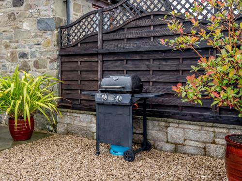 a charcoal grill sitting in front of a wall at The Stables in Llanfair Caereinion