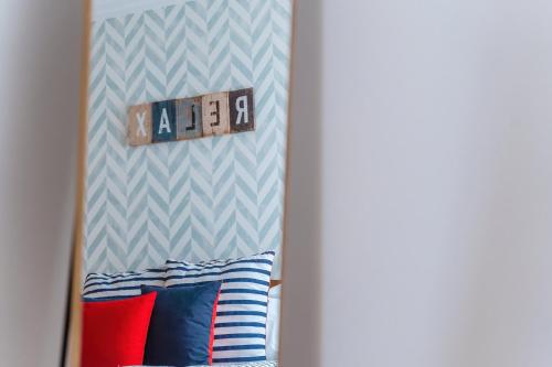 een spiegel in een kamer met een kussen en een klok bij Farol Beach Place in Nazaré