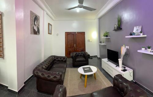 a living room with a couch and a tv at Peaceful Stay 1SR in Cotonou
