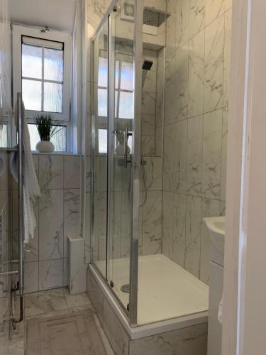 uma casa de banho com um chuveiro e um lavatório. em New look flat In Waterloo em Londres