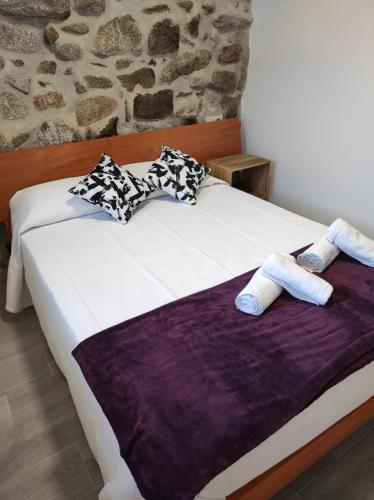 łóżko z 2 poduszkami i fioletowym kocem w obiekcie Casa do Vale - Casa Termal - Gerês / Xures w mieście Lobios