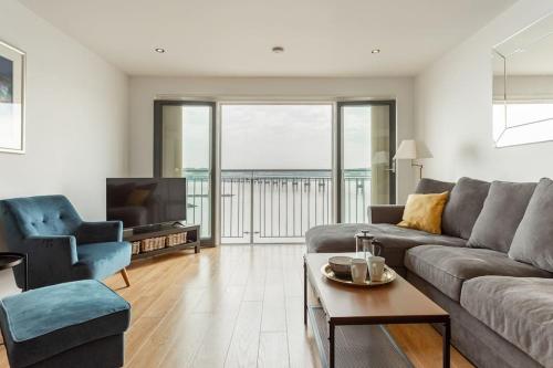 a living room with a couch and a tv at Lux Waterfront 2 bed Apt w free parking & river views, City Centre 15 min walk in Dundee