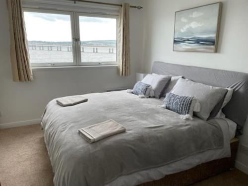 a bedroom with a large bed with a window at Lux Waterfront 2 bed Apt, V&A 10min walk, St Andrew's Golf 25min drive in Dundee