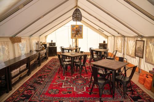 un comedor con mesas y sillas en una tienda de campaña en Dreamcatcher Tipi Hotel en Gardiner