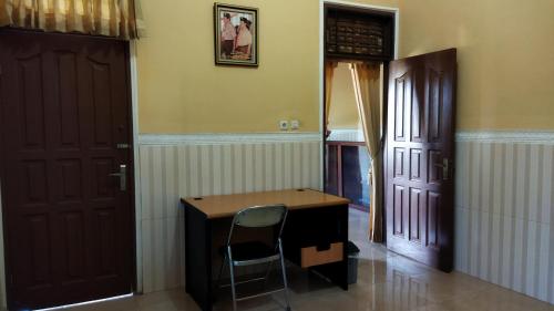 a desk in a room with two doors and a chair at Bougenville Homestay in Lembar