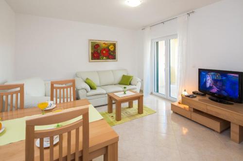 a living room with a couch and a tv at Apartments Leon in Podstrana