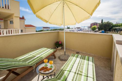 a balcony with two chairs and an umbrella at Apartments Leon in Podstrana