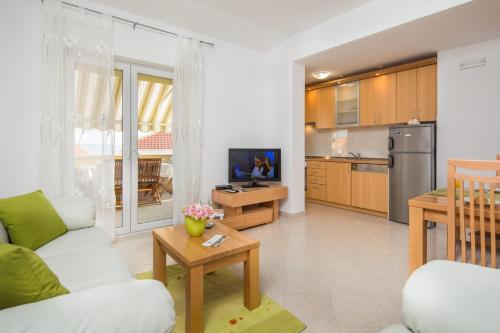 a living room with a couch and a kitchen at Apartments Leon in Podstrana