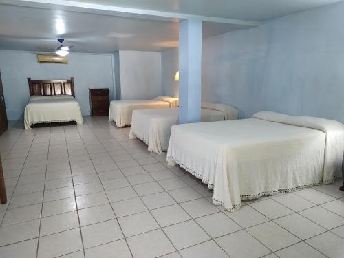 a room with two beds and a tiled floor at Freedom Shores "La Gringa" Hotel - Universally Designed in Isla Aguada