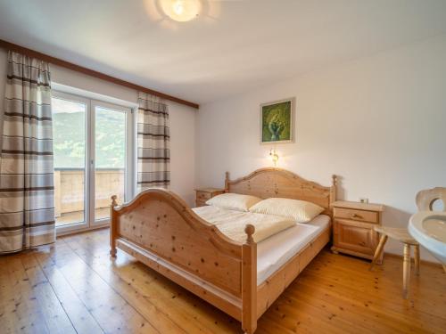 een slaapkamer met een groot houten bed en een raam bij Obersteiner 1 in Zell am Ziller