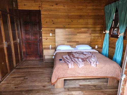 a bedroom with a bed in a wooden cabin at La Colmena del Arroyazo in Arroyo Frío