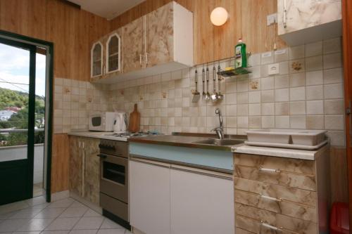 a kitchen with a sink and a counter top at Apartments by the sea Zivogosce - Porat, Makarska - 4878 in Igrane