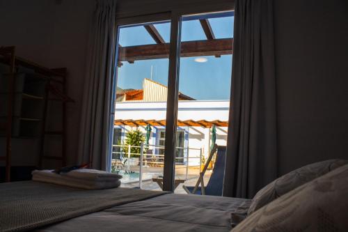 a bedroom with a bed and a large glass window at Apartamentos Atenea Jerte in Jerte