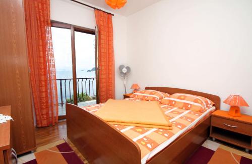 a bedroom with a bed and a balcony at Apartments by the sea Sobra, Mljet - 4898 in Babino Polje