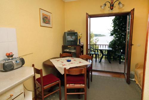 kuchnia i jadalnia ze stołem i telewizorem w obiekcie Apartments by the sea Sobra, Mljet - 4898 w mieście Babino Polje