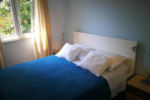 a bedroom with a blue bed with pillows and a window at Apartments by the sea Sobra, Mljet - 4936 in Babino Polje
