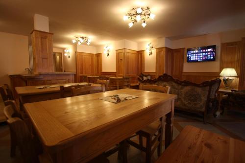 una sala da pranzo con tavoli e sedie in legno di Villa Giuditta Residence a Gaby