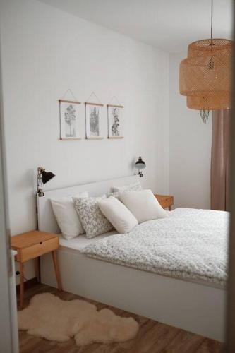a bedroom with a bed with white sheets and pillows at Bon Repos Apartmán in Donovaly
