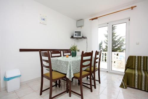 ein Esszimmer mit Tisch und Stühlen in der Unterkunft Apartments with parking spaces Barbat, Rab - 4962 in Rab