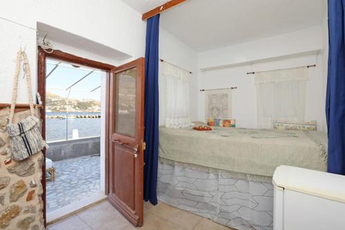 Habitación con dormitorio con cama y ventana en Principessa, en Kalymnos