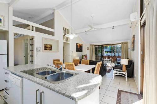 a kitchen with a sink and a living room at Wolngarin Holiday Resort Noosa in Noosaville