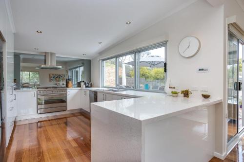 a large white kitchen with a clock on the wall at Holiday Haven with Pool in Sorrento