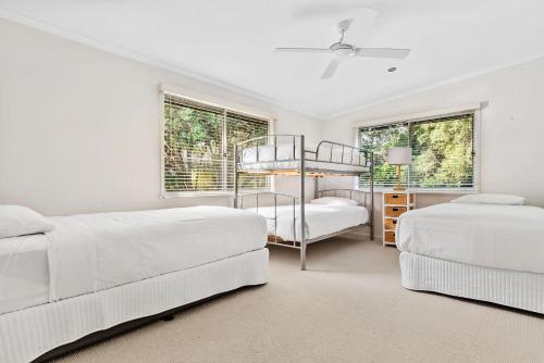 a white bedroom with two beds and two windows at Holiday Haven with Pool in Sorrento