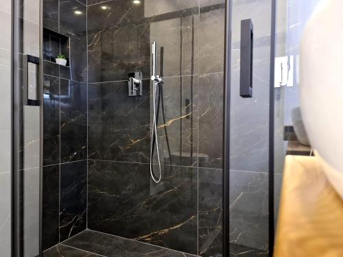 a bathroom with a shower with a glass door at Restaurant & Apartments Getaway Pri Kobalu in Vipava
