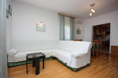a living room with a white couch and a table at Apartments by the sea Barbat, Rab - 5005 in Barbat na Rabu