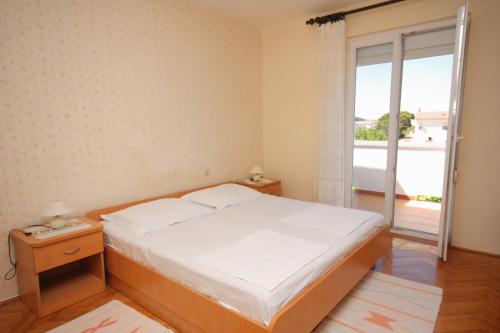 a bedroom with a bed and a large window at Apartments with a parking space Palit, Rab - 4957 in Mundanije