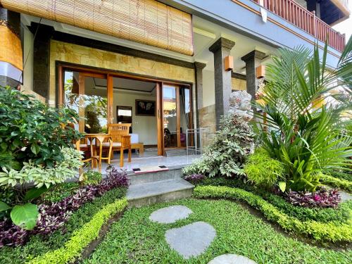 a home with a patio with a table and chairs at Sari Murni in Ubud