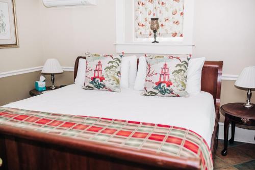 a bedroom with a bed with white sheets and pillows at Benn Conger Inn in Groton