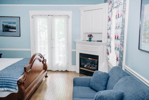 a living room with a bed and a fireplace at Benn Conger Inn in Groton
