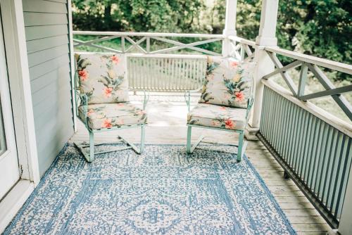 two chairs sitting on a porch with a rug at Benn Conger Inn in Groton
