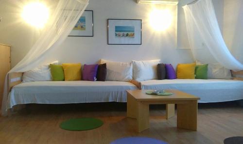 ein Wohnzimmer mit zwei weißen Sofas und bunten Kissen in der Unterkunft Apartments with a parking space Rogac, Solta - 5165 in Grohote