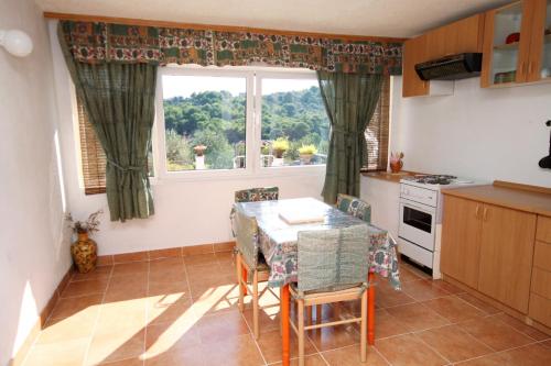 eine Küche mit einem Tisch und Stühlen sowie einem Fenster in der Unterkunft Apartments with a parking space Rogac, Solta - 5165 in Grohote