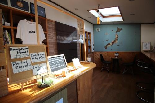 a restaurant with a counter with a tshirt on the wall at 晴家(HALELUYA) Guest House in Fujikawaguchiko