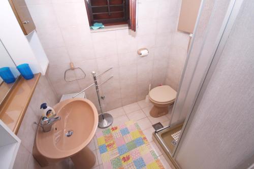 La petite salle de bains est pourvue d'un lavabo et de toilettes. dans l'établissement Apartments by the sea Stomorska, Solta - 5164, à Stomorska