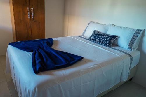 a large white bed with blue sheets and pillows at Casa na Praia dos Carneiros/PE. Cond. Village IV. in Tamandaré