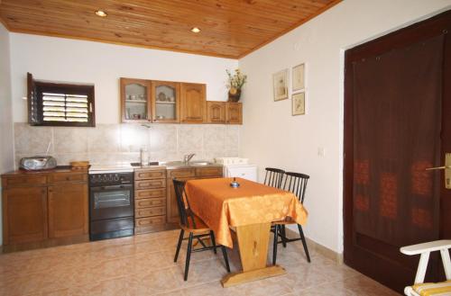 une cuisine avec une table et un chiffon de table. dans l'établissement Apartments by the sea Stomorska, Solta - 5164, à Stomorska
